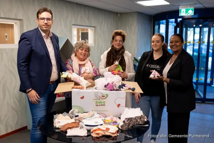 Wethouder Chris Boer reikt babypakket uit